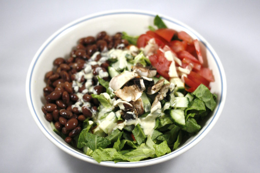 big buddha bowl with beans and ceasar dressing